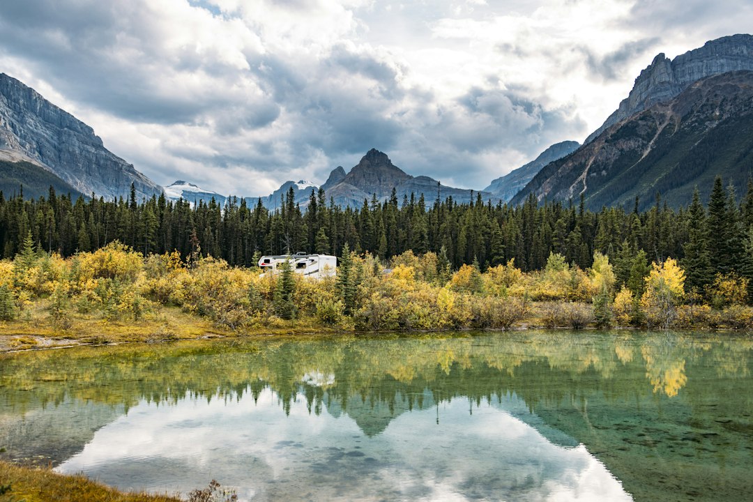 Camper immerso nella natura vicino a un lago di montagna